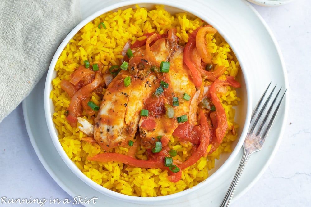 Tilapia Fish Veracruz in a white bowl with spanish rice.