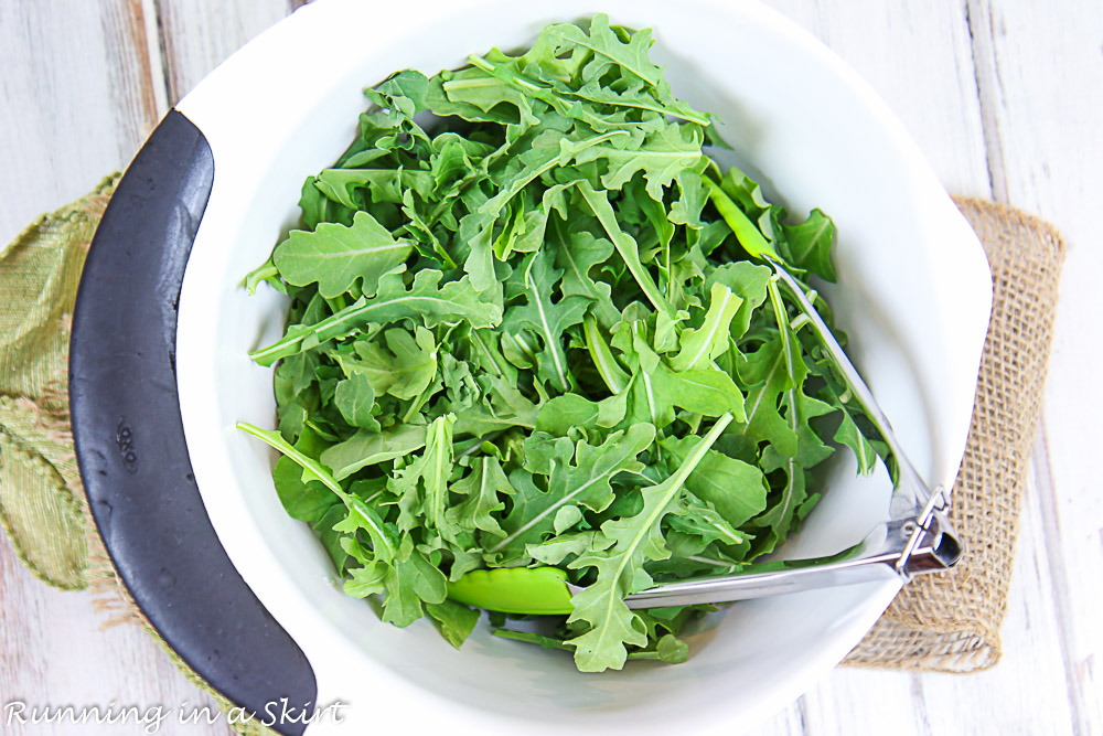 Shot showing how to toss the arugula.