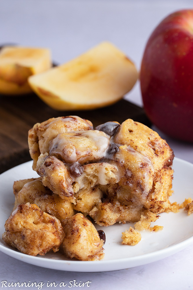 French Toast Crock Pot Cinnamon Roll Casserole on a white plate with an apple in the background.