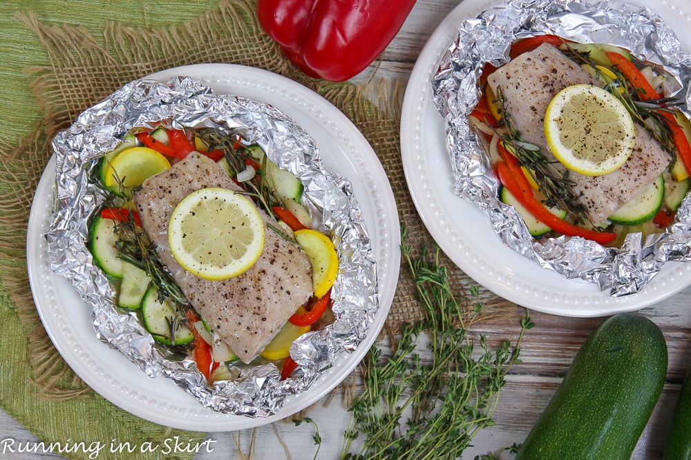 Overhead shot of Baked Fish in Foil on white plates.