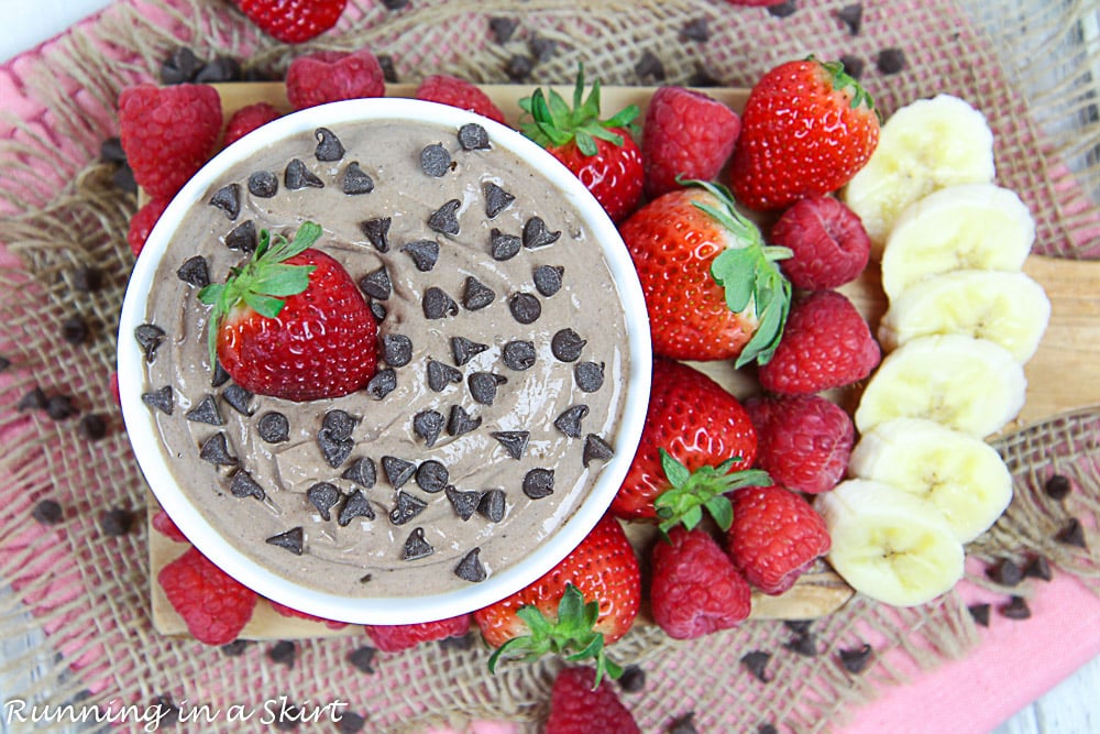 Overhead shot of the greek yogurt fruit dip in a white bowl with fruit dippers surrounding it.