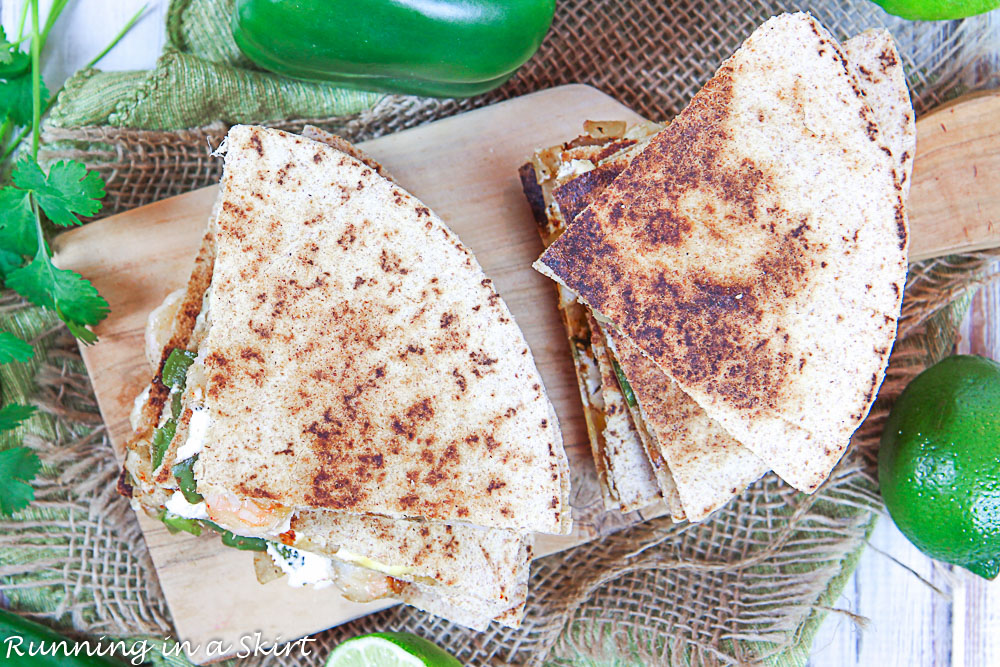 Overhead shot of the shrimp quesadilla recipe on a cutting board with cilantro and lime.