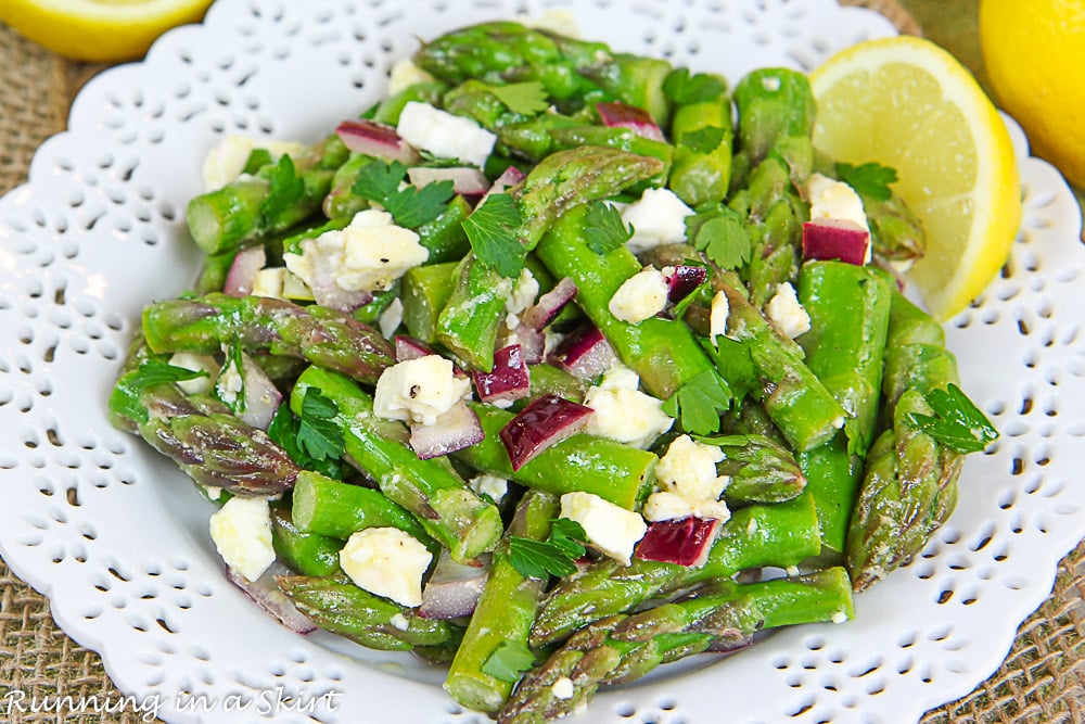 Asparagus Salad on white plate with feta and lemon.