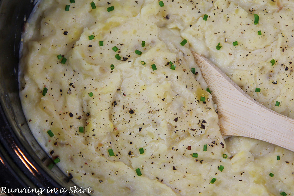 Mashed Potatoes in Crock Pot with a wooden spoon.