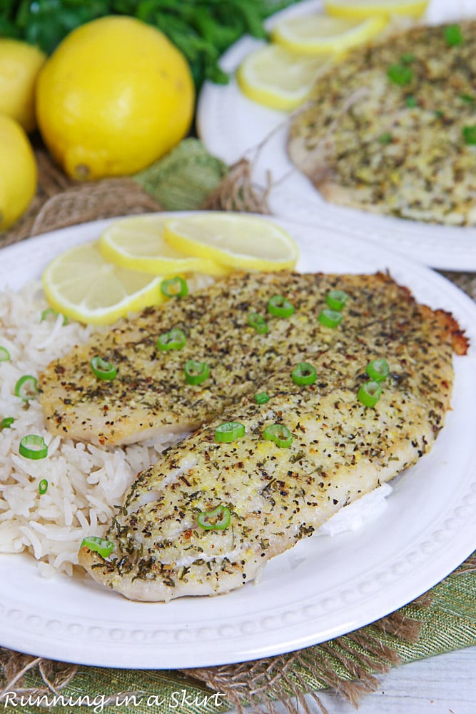 Lemon Pepper Tilapia on a white plate with rice and lemon.