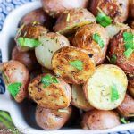 Herb and Garlic Roasted Baby Red Potatoes in a white baking dish.