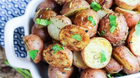 Herb and Garlic Roasted Baby Red Potatoes in a white baking dish.