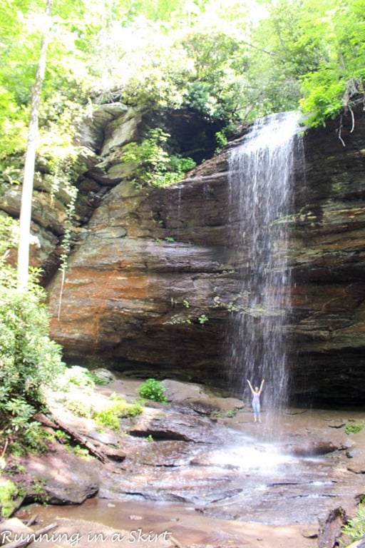 Moore Cove Falls with someone standing behind the waterfall.