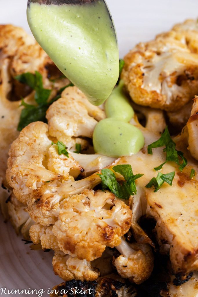 Grilled Cauliflower Steak with a drizzle of green goddess sauce.