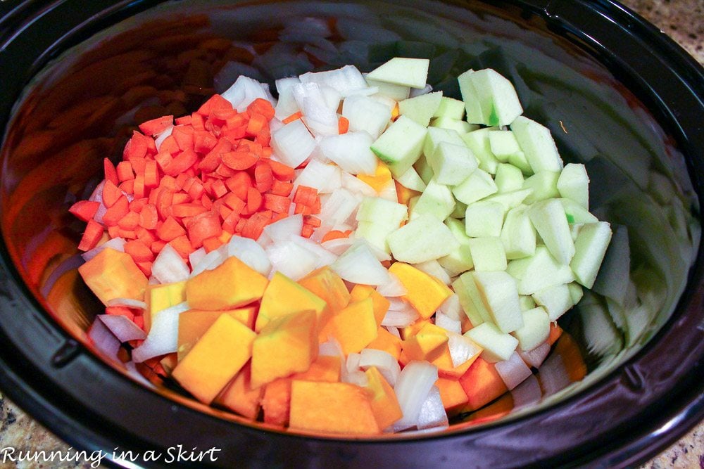 Butternut squash, carrots, apples and onion in a crock pot before the soup is cooked.