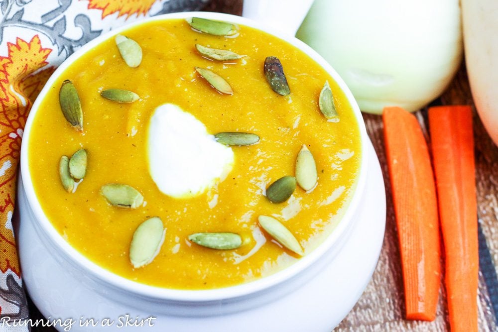 Close up of the Butternut Squash Soup recipe Crock Pot in a white bowl with pumpkin seeds.