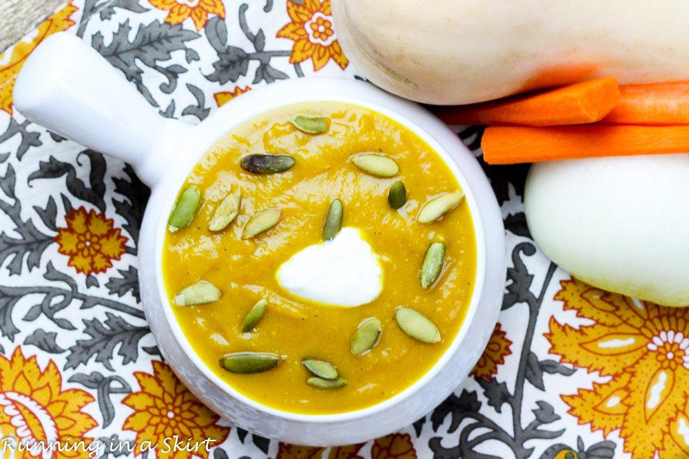 Overhead shot of Crock Pot Butternut Squash Soup recipe in a white bowl on a napkin.