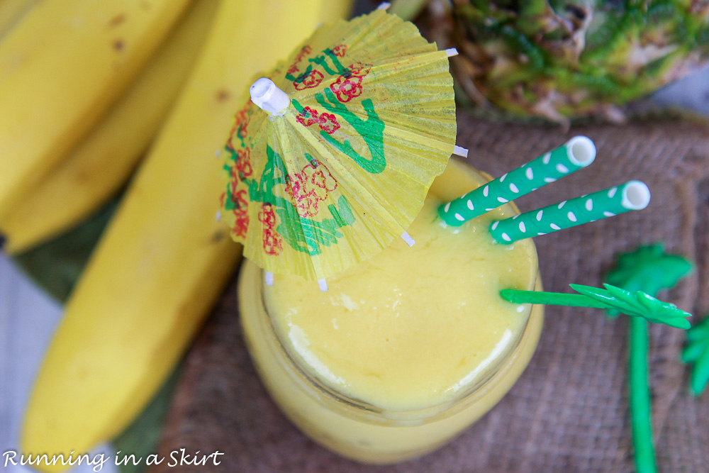 Healthy Mango Smoothie overhead shot in a glass jar with a drink umbrella.