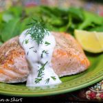 Baked Lemon Salmon with Creamy Dill Sauce on a green plate.