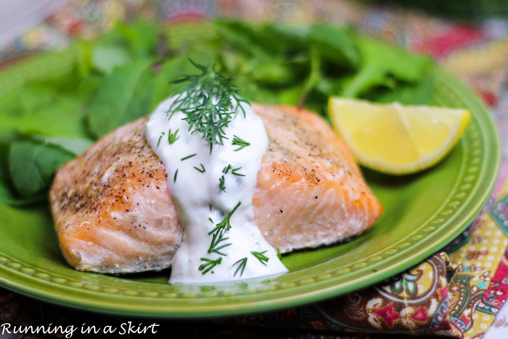 Baked Lemon Salmon with Creamy Dill Sauce on a green plate.