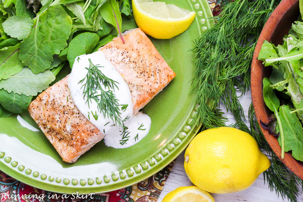 Baked Lemon Salmon with Creamy Dill Sauce on a green plate.