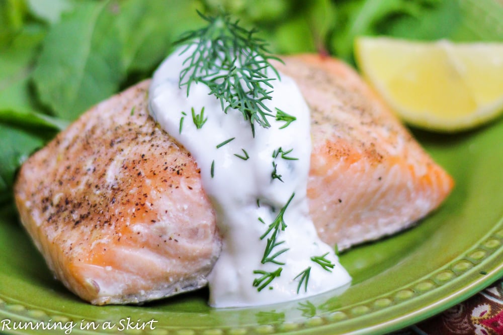 Baked Lemon Salmon with Creamy Dill Sauce on a green plate.