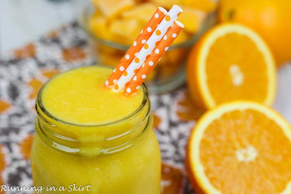 Mango Orange Smoothie in a glass jar with colorful straws.
