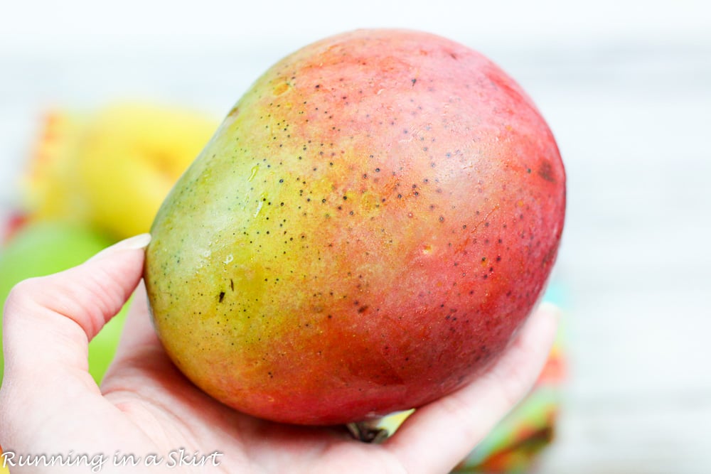 Hand holding a mango.