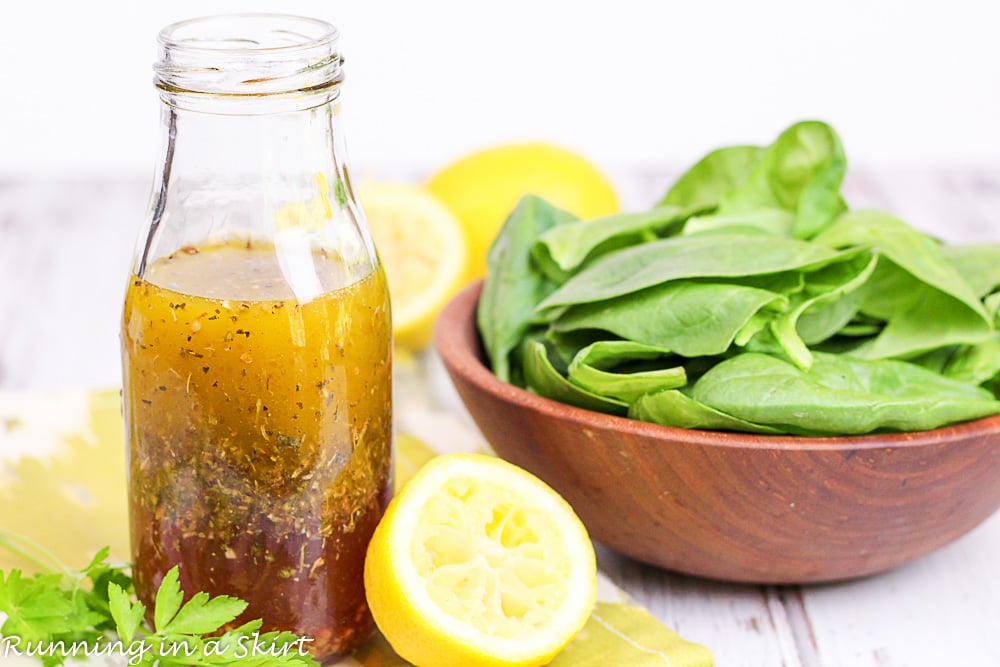 Bottle of healthy salad dressing in a glass bottle next to a bowl of spinach. / Running in a Skirt