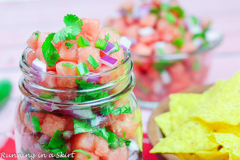 Glass jar with salsa and wooden bowl with chips.