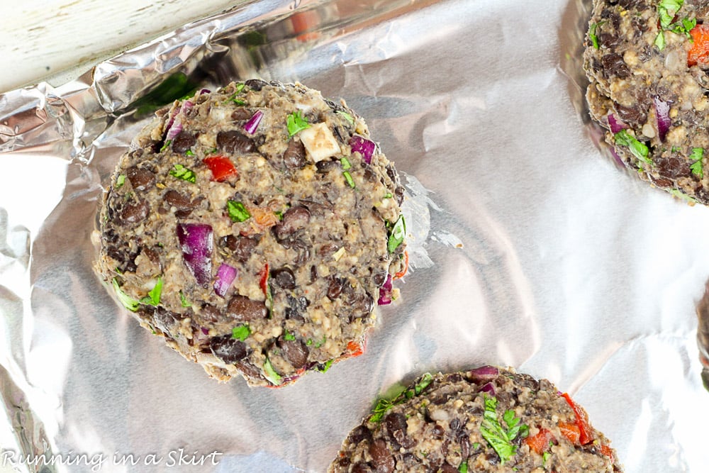 How to Make Black Bean Burgers photo showing the homemade Black Bean Burgers on a baking sheet lined with foil.