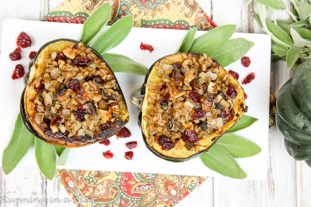 Stuffed acorn squash plated with fresh sage on a white plate.