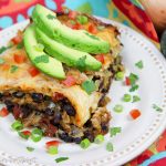 Crock Pot Vegetarian Enchilada Casserole on a white plate topped with garnishes.