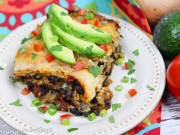 Crock Pot Vegetarian Enchilada Casserole on a white plate topped with garnishes.