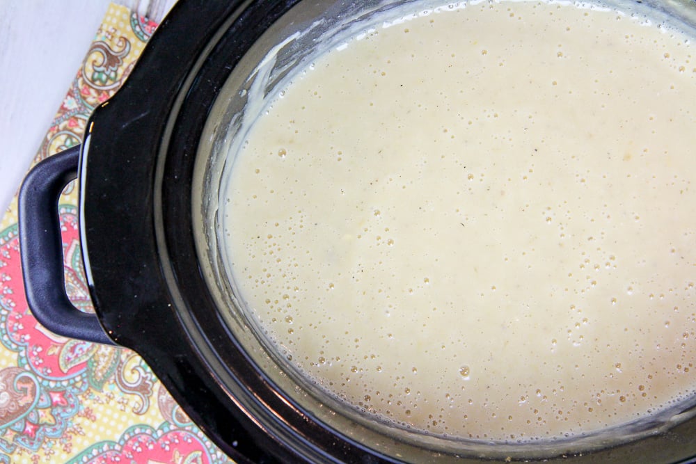 Crock pot with vegetarian potato soup cooking.