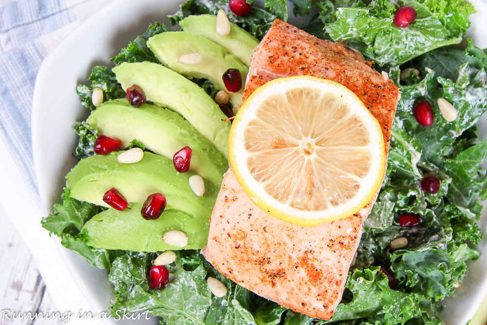 Baked Salmon Kale Salad recipe with Tahini Dressing in a white bowl.