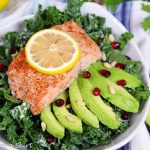 Baked Salmon Kale Salad with Tahini Dressing in a white bowl.