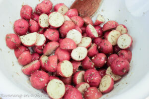 Sliced baby red potatoes in a mixing bowl.