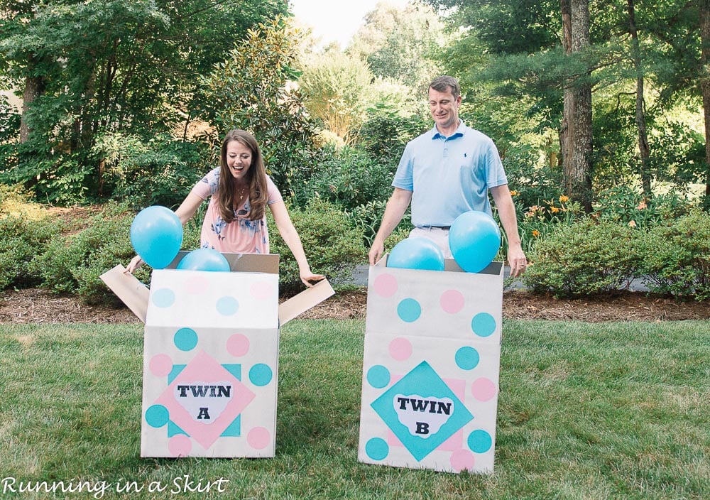 Blue balloons coming out of boxes at a twin gender reveal with Mom and Dad opening boxes.