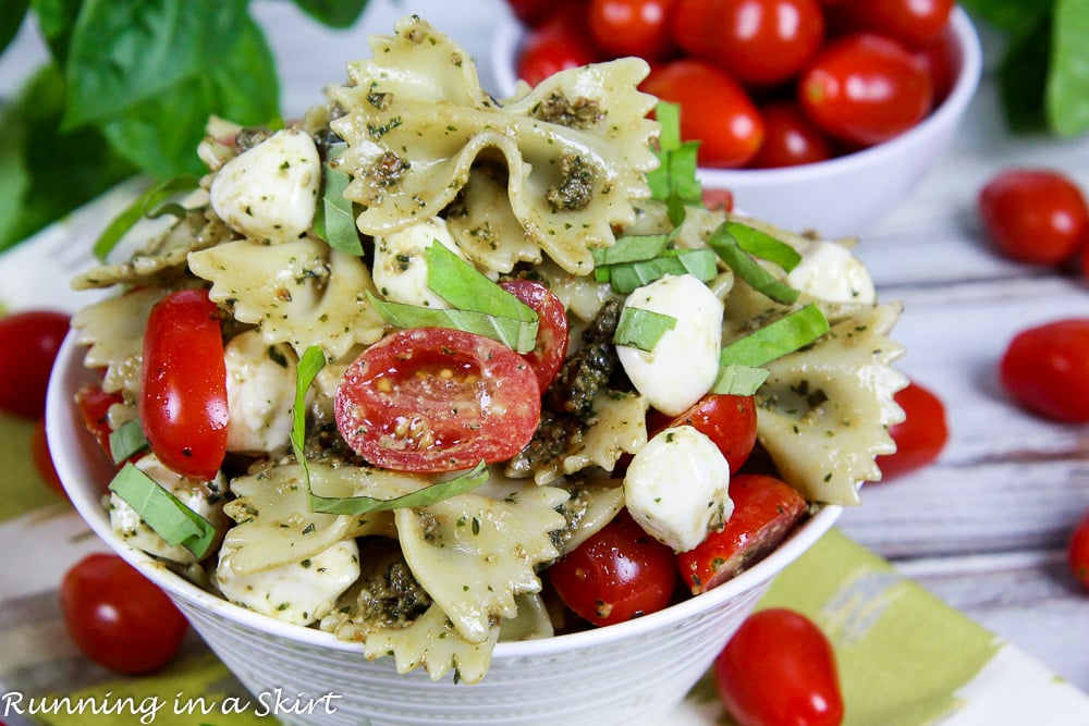 4 Ingredient Caprese Pasta Salad with pesto in a bowl with garnish.