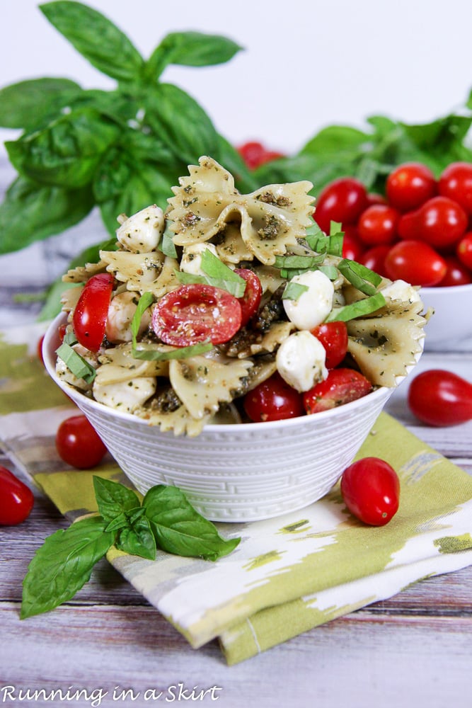 Caprese Pasta Salad with pesto - 4 Ingredient Pasta Salad with fresh basil in a bowl.