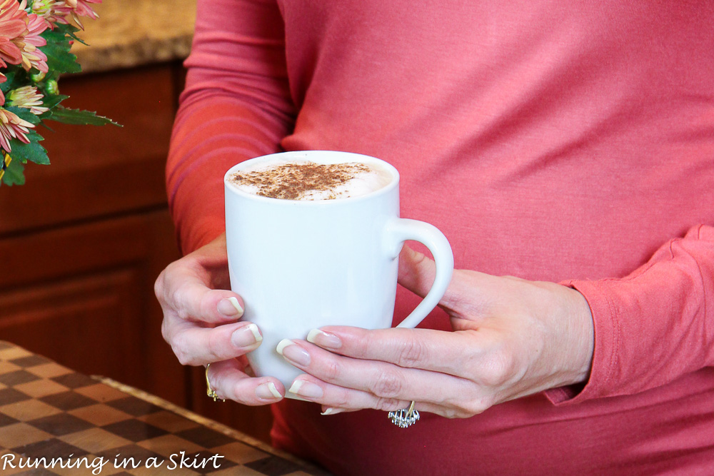 Hands holding mug of dirty chai latte.