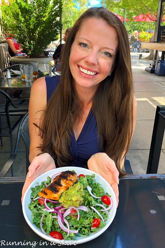 Girl holding a plate with a salmon salad.