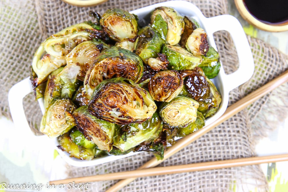 Overhead shot of the Teriyaki Brussels Sprouts in a white dish with chop sticks.