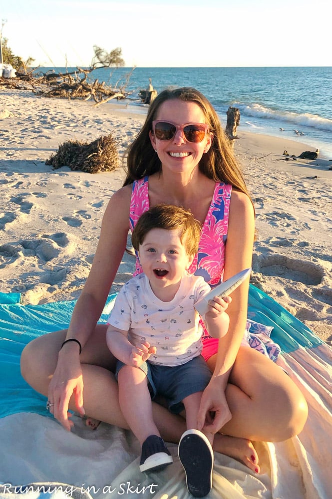 Mom holding child on the beach in Sanibel. sharing the places to eat on Sanibel.