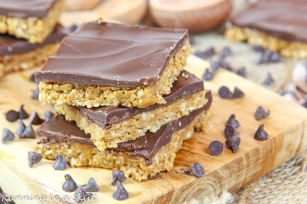 Chocolate Peanut Butter Bars stacked on a wood cutting board.