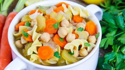 Closeup of soup with chickpeas, carrots, celery, onions and garlic.