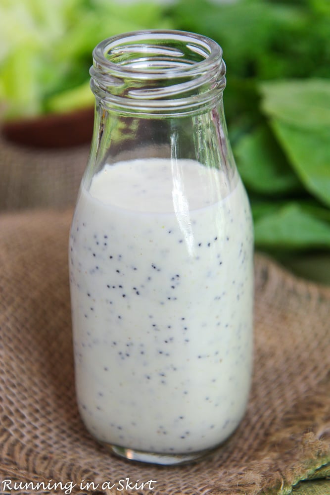 Glass bottle of Dressing sitting on napkin.