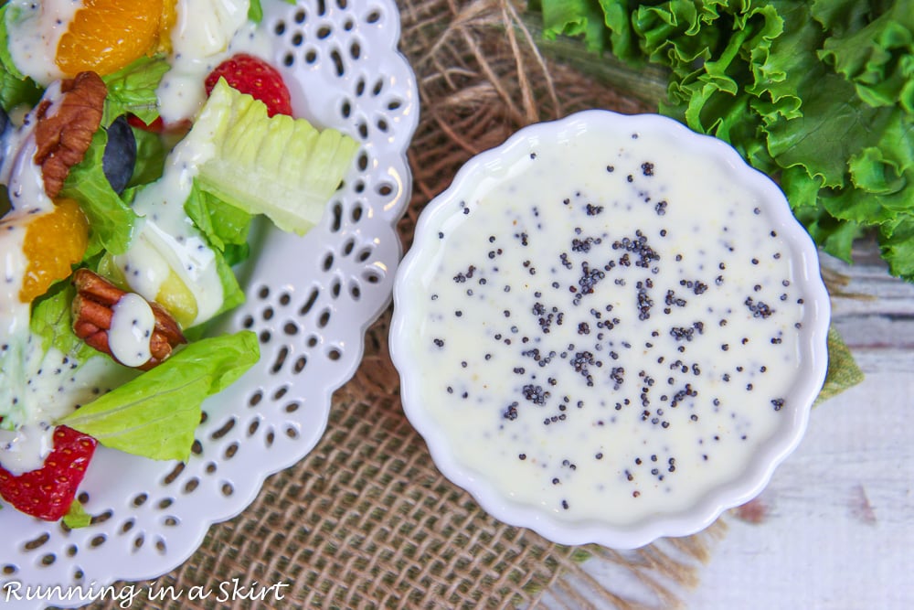 Overhead shot of strawberry salad and side dish of dressing.