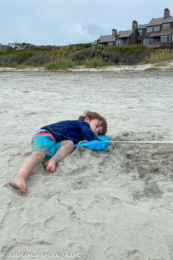 Toddler laying on sand Kiawah Island beaches.