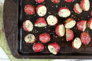 Everything But the Bagel Roasted Potatoes cut in half on a baking sheet.