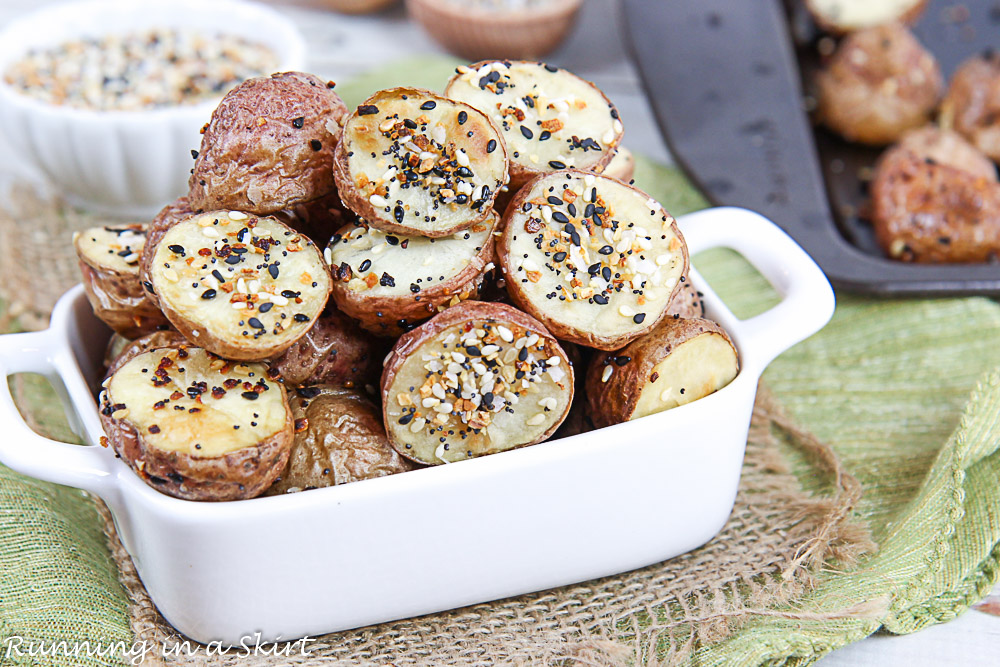 Finished product of the Everything Bagel Roasted Potatoes in a white dish with a baking sheet in the background.