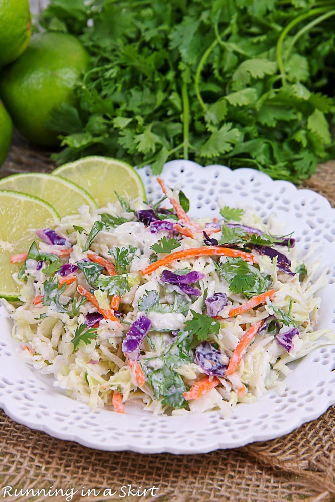 Finished product of the slaw with limes and cilantro in the background.