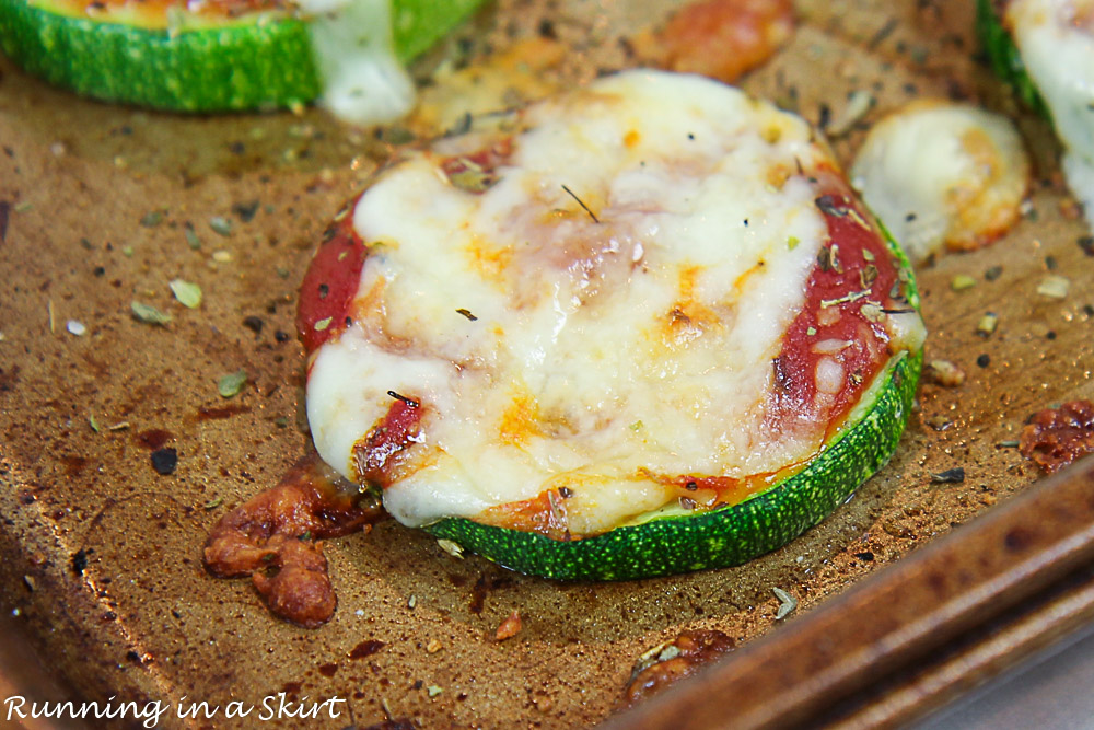 Closeup of zucchini pizza bites on a baking sheet coming out of the oven.