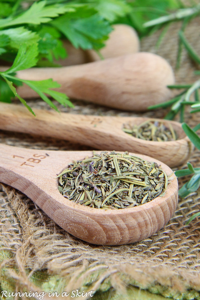 Herbs de Provence recipe in several wooden measuring spoons on a green napkin.